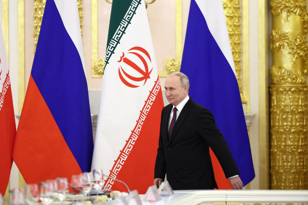 Rusk&yacute; prezident Vladimir Putin, v pozad&iacute; vlajky Ruska a Ir&aacute;nu. FOTO: Reuters