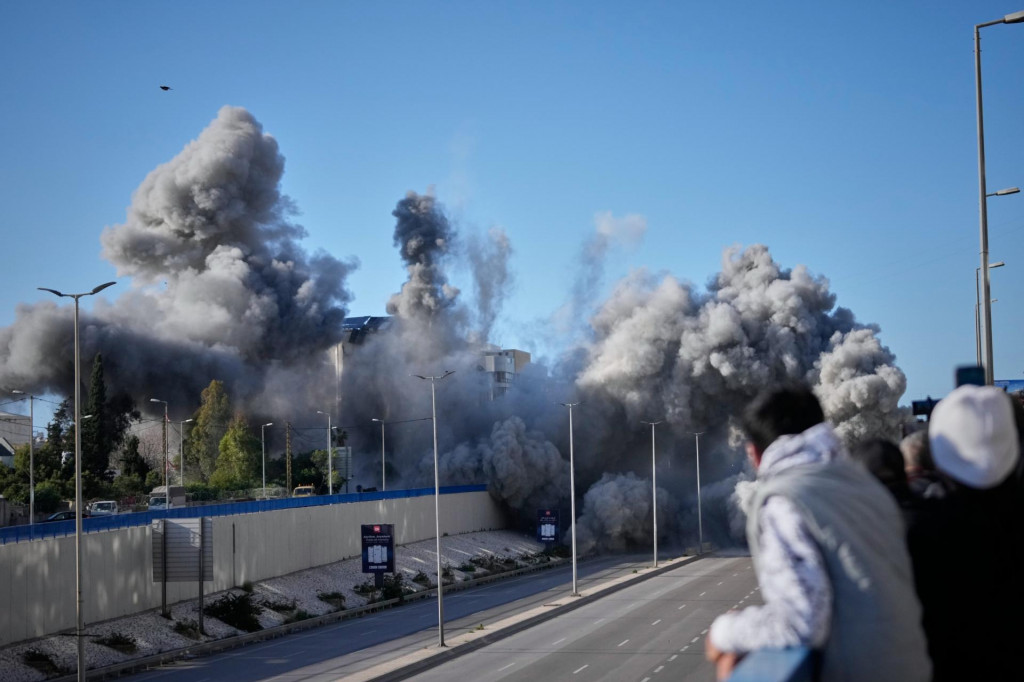 Okoloid&uacute;ci sa pozeraj&uacute; ako dym st&uacute;pa z miesta izraelsk&yacute;ch leteck&yacute;ch &uacute;tokov na obytn&uacute; budovu pri ceste na letisko v Bejr&uacute;te. FOTO: TASR/AP