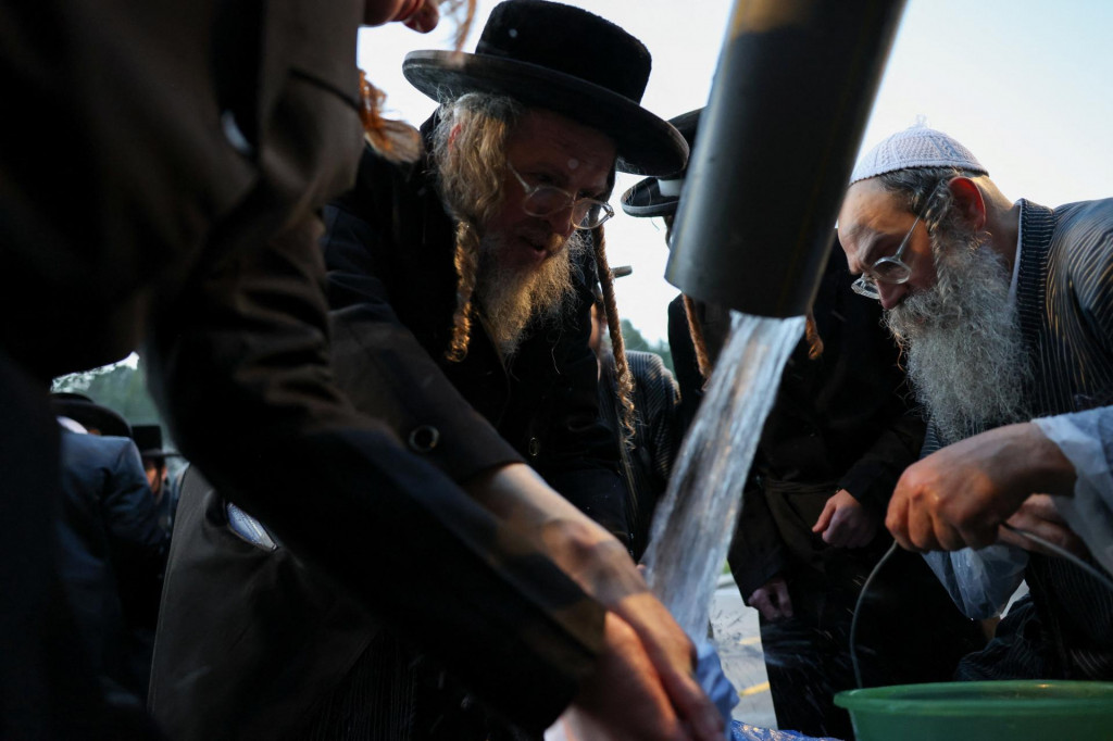 Ultraortodoxn&iacute; Židia sa z&uacute;častňuj&uacute; obradu, počas ktor&eacute;ho sa z pr&iacute;rodn&eacute;ho prameňa zbiera voda na pr&iacute;pravu macy, tradičn&eacute;ho nekvasen&eacute;ho chleba, ktor&yacute; sa konzumuje počas židovsk&eacute;ho sviatku Pesach, neďaleko Jeruzalema. FOTO: Reuters