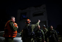 Z&aacute;chran&aacute;ri sa zhromažďuj&uacute; na mieste dopadu rakety po spŕ&scaron;ke rakiet odp&aacute;len&yacute;ch z Ir&aacute;nu v Ramat Gan v Izraeli. FOTO: Reuters