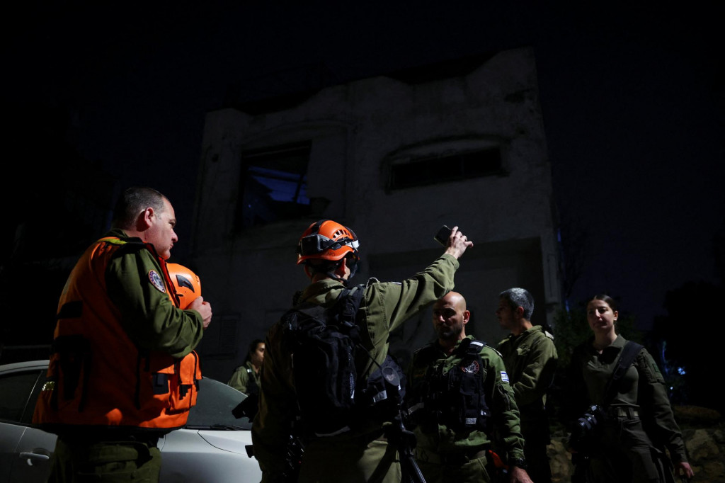 Z&aacute;chran&aacute;ri sa zhromažďuj&uacute; na mieste dopadu rakety po spŕ&scaron;ke rakiet odp&aacute;len&yacute;ch z Ir&aacute;nu v Ramat Gan v Izraeli. FOTO: Reuters
