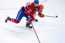 Slovensk&yacute; hokejista v drese Montrealu Juraj Slafkovsk&yacute; (20) a hr&aacute;č Anaheimu Ducks Jackson LaCombe (2) bojuj&uacute; o puk v z&aacute;pase z&aacute;morskej NHL Montreal Canadiens - Anaheim Ducks v Montreale v nedeľu 15. marca 2026. FOTO: TASR/AP