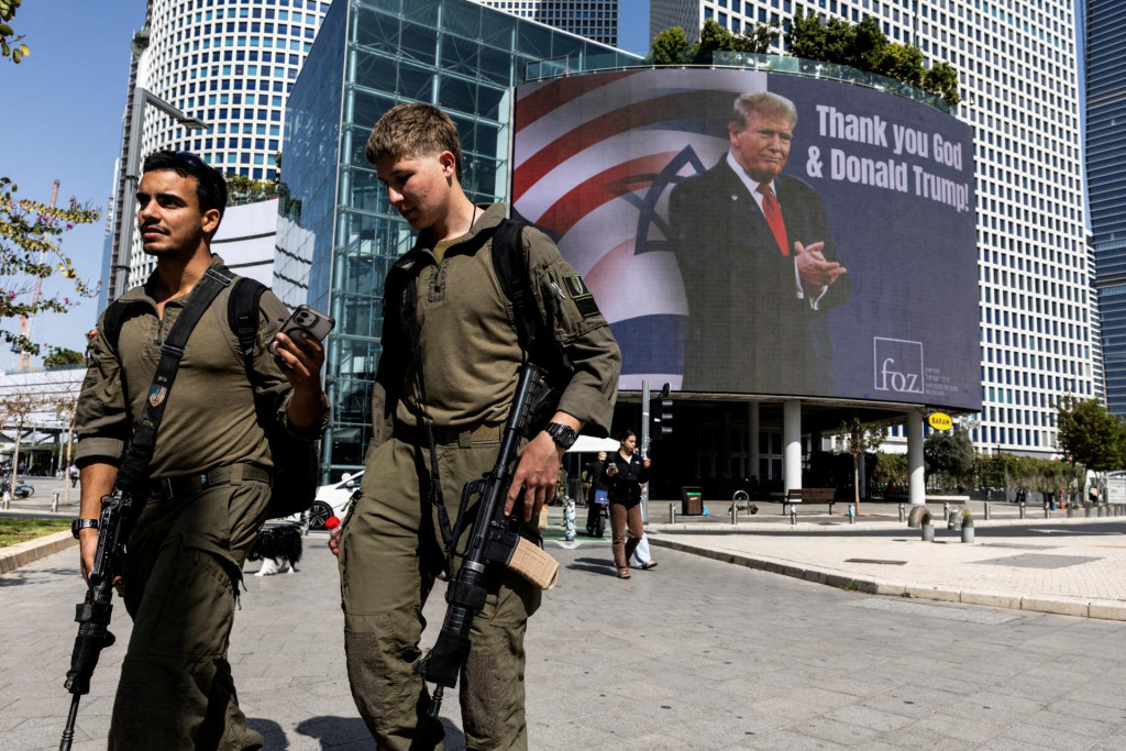 Izraelsk&iacute; vojaci prech&aacute;dzaj&uacute; okolo billboardu, ktor&yacute; si objednala evanjelick&aacute; skupina a na ktorom je obr&aacute;zok americk&eacute;ho prezidenta Donalda Trumpa s n&aacute;pisom &bdquo;Ďakujeme Bohu a Donaldovi Trumpovi&ldquo;. FOTO: Reuters