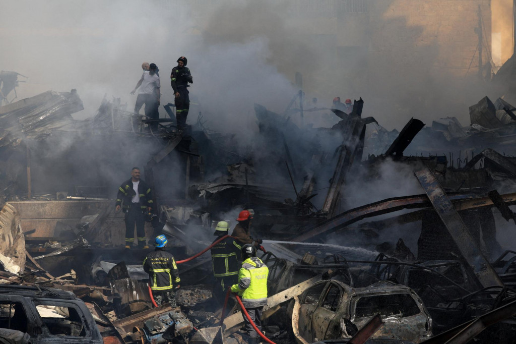Z&aacute;chran&aacute;ri pracuj&uacute; na mieste izraelsk&eacute;ho &uacute;toku v Bejr&uacute;te. FOTO: Reuters