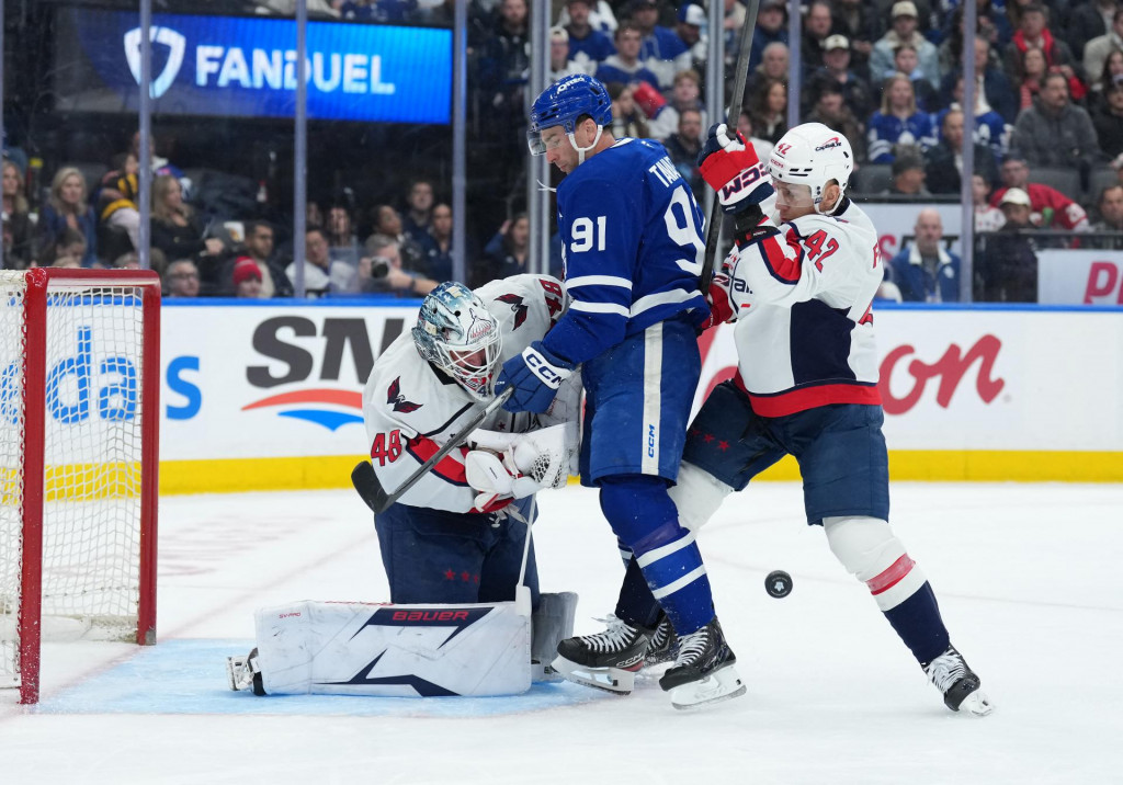 Center t&iacute;mu Toronto Maple Leafs John Tavares (91) počas prvej tretiny v s&uacute;boji s obrancom t&iacute;mu Washington Capitals Martinom Feherv&aacute;rym (42) pred brank&aacute;rom Loganom Thompsonom (48). FOTO: Nick Turchiaro/Imagn Images