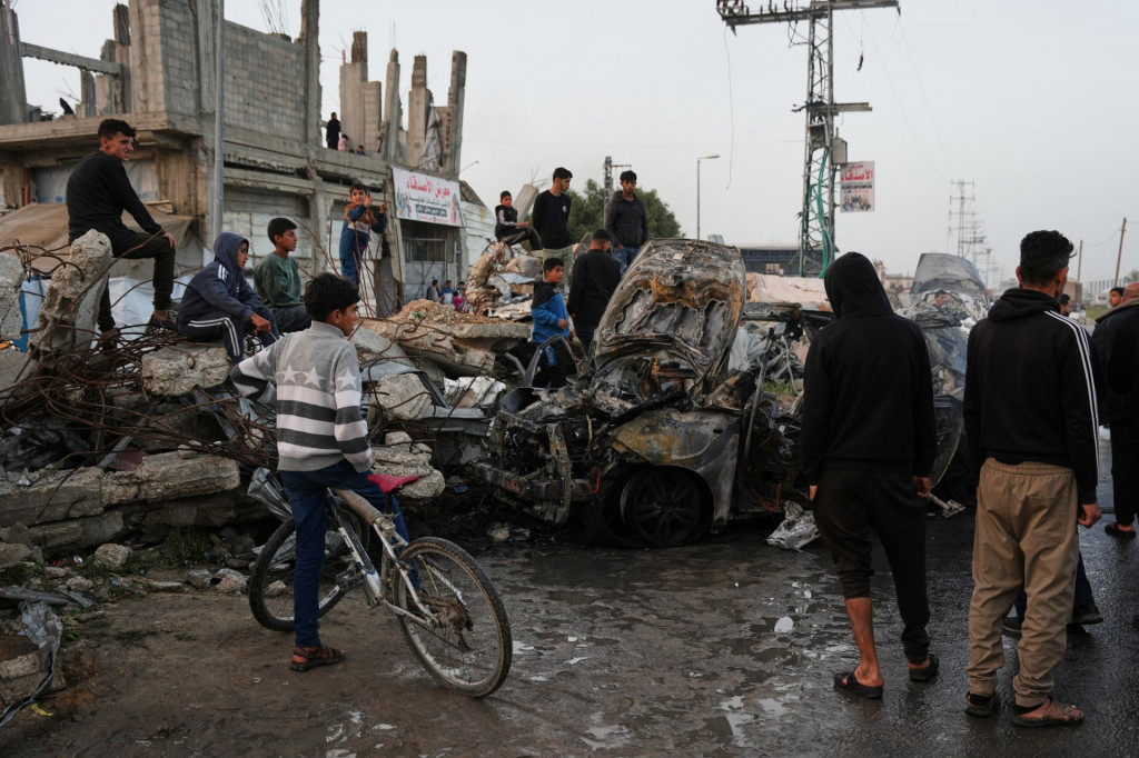 Palest&iacute;nčania si prezeraj&uacute; vrak auta po &uacute;toku izraelskej arm&aacute;dy na utečeneck&yacute; t&aacute;bor Magh&aacute;z&iacute; v centr&aacute;lnej časti P&aacute;sma Gazy v sobotu 4. apr&iacute;la 2026. FOTO: TASR/AP