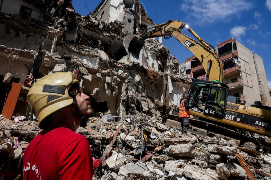 Z&aacute;chran&aacute;ri s pomocou ťažk&yacute;ch strojov pracuj&uacute; na mieste izraelsk&eacute;ho &uacute;toku na južnom predmest&iacute; Bejr&uacute;tu. FOTO: Reuters