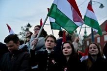 Ľudia držia maďarsk&eacute; vlajky v deň parlamentn&yacute;ch volieb v Maďarsku. FOTO: Reuters