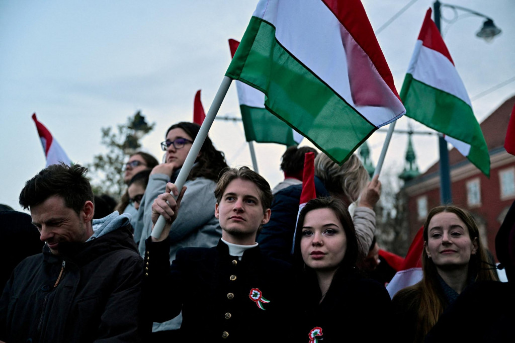 Ľudia držia maďarsk&eacute; vlajky v deň parlamentn&yacute;ch volieb v Maďarsku. FOTO: Reuters