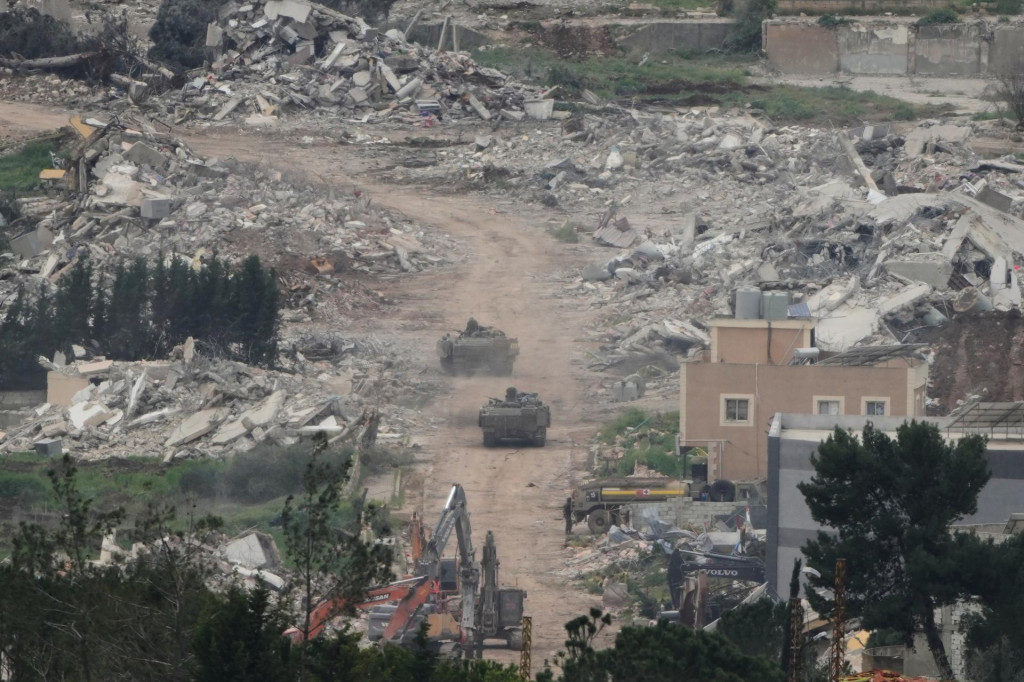 Izraelsk&iacute; vojaci jazdia na vojenskom vozidle cez oblasti na juhu Libanonu. FOTO: TASR/AP