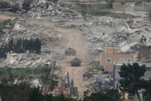 Izraelsk&iacute; vojaci jazdia na vojenskom vozidle cez oblasti na juhu Libanonu. FOTO: TASR/AP