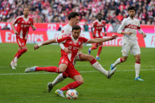 Hr&aacute;či Bayernu Mn&iacute;chov Leon Goretzka a Angelo Stiller zo Stuttgartu v s&uacute;boji o loptu. FOTO: TASR/AP