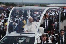 P&aacute;pež Lev XIV. zdrav&iacute; veriacich počas jeho pr&iacute;chodu v papamobile celebrovať z&aacute;verečn&uacute; sv&auml;t&uacute; om&scaron;u počas jeho n&aacute;v&scaron;tevy v angolskom meste Saurimo. FOTO: TASR/AP