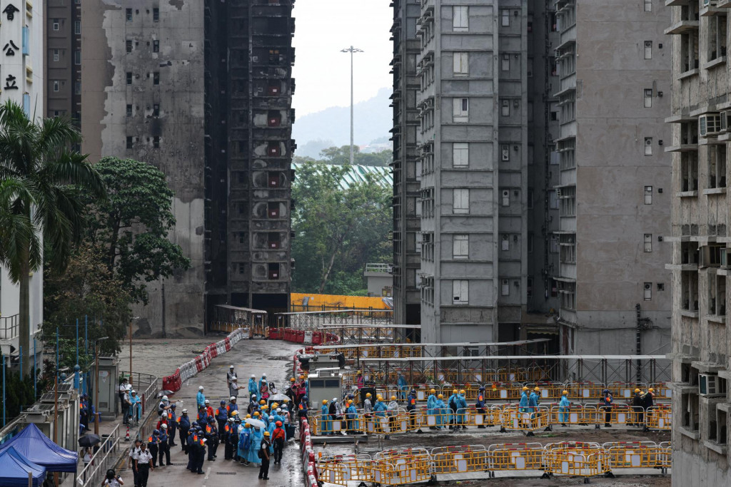 Obyvatelia kr&aacute;čaj&uacute; k budove Wang Fuk Court, aby si vyzdvihli osobn&eacute; veci pri svojej prvej n&aacute;v&scaron;teve po smrteľnom požiari v Hongkongu. FOTO: Reuters