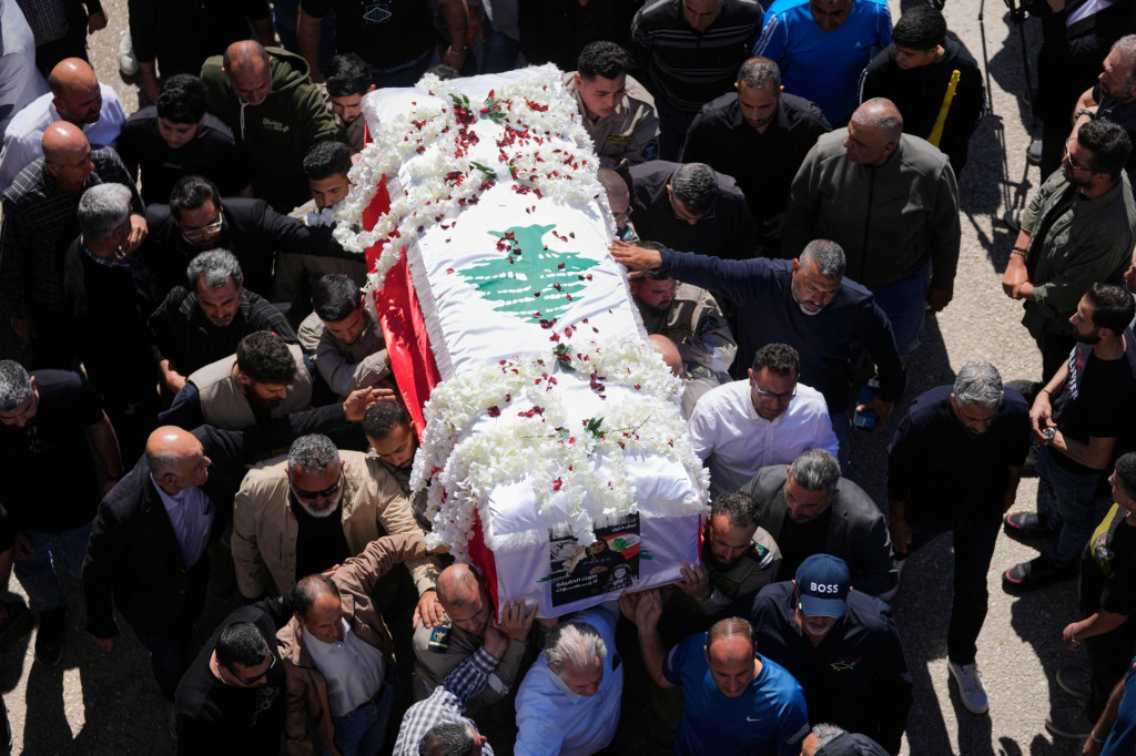 Ľudia nes&uacute; rakvu s pozostatkami libanonskej novin&aacute;rky Amaly Chal&iacute;lovej počas pohrebn&eacute;ho sprievodu v obci na juhu Libanonu. FOTO: TASR/AP
