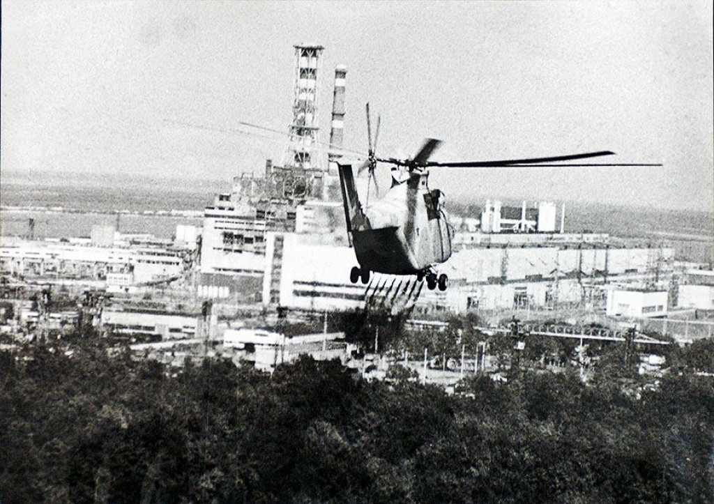 Fotografia z 12. m&aacute;ja 1986 zachyt&aacute;va vrtuľn&iacute;k, ktor&yacute; rozpra&scaron;uje chemik&aacute;lie určen&eacute; na elimin&aacute;ciu radi&aacute;cie zo zničen&eacute;ho reaktora jadrovej elektr&aacute;rne Černobyľ. FOTO: Fotobanka IAEA