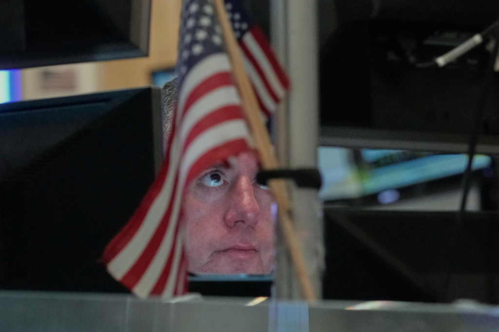 Burzov&yacute; makl&eacute;r Justin Flinn obchoduje na burze v New Yorku v momente, keď akciov&eacute; indexy l&aacute;mu historick&eacute; maxim&aacute;. FOTO FOTO TASR/AP