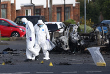 Forenzn&iacute; experti vy&scaron;etruj&uacute; na mieste v&yacute;buchy bomby v aute, ku ktor&eacute;mu v bl&iacute;zkosti policajnej stanice na predmest&iacute; Belfastu. FOTO: TASR/AP