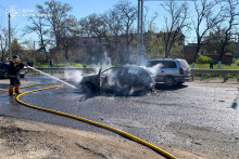 Hasič hasia auto, ktor&eacute; bolo po&scaron;koden&eacute; počas rusk&eacute;ho raketov&eacute;ho &uacute;toku v meste Merefa. FOTO: Reuters/Tlačov&aacute; služba &Scaron;t&aacute;tnej z&aacute;chrannej služby Ukrajiny v Charkovskej oblasti