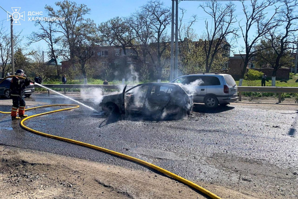 Hasič hasia auto, ktor&eacute; bolo po&scaron;koden&eacute; počas rusk&eacute;ho raketov&eacute;ho &uacute;toku v meste Merefa. FOTO: Reuters/Tlačov&aacute; služba &Scaron;t&aacute;tnej z&aacute;chrannej služby Ukrajiny v Charkovskej oblasti
