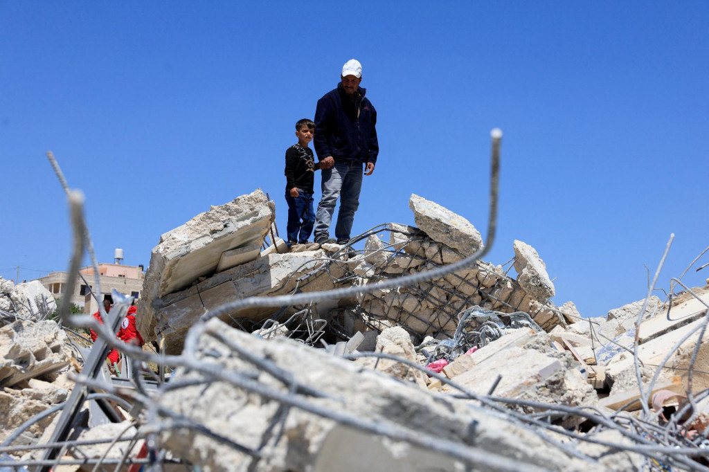 Palest&iacute;nčania si prezeraj&uacute; budovu zničen&uacute; izraelsk&yacute;mi ťažk&yacute;mi strojmi neďaleko Hebronu na Izraelom okupovanom Z&aacute;padnom brehu Jord&aacute;nu. FOTO: Reuters