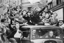 Oslavy Dňa v&iacute;ťazstva v Eur&oacute;pe v Lond&yacute;ne 8. m&aacute;ja 1945. Skupina ľud&iacute; oslavuje koniec druhej svetovej vojny na n&aacute;kladnom aute prech&aacute;dzaj&uacute;com cez Strand. FOTO: Imperial War Museums/HU 41808