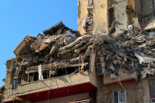 Z&aacute;chran&aacute;r prehľad&aacute;va trosky zničenej budovy v &scaron;tvrti D&aacute;h&iacute;ja, na južnom predmest&iacute; Bejr&uacute;tu. FOTO: TASR/AP