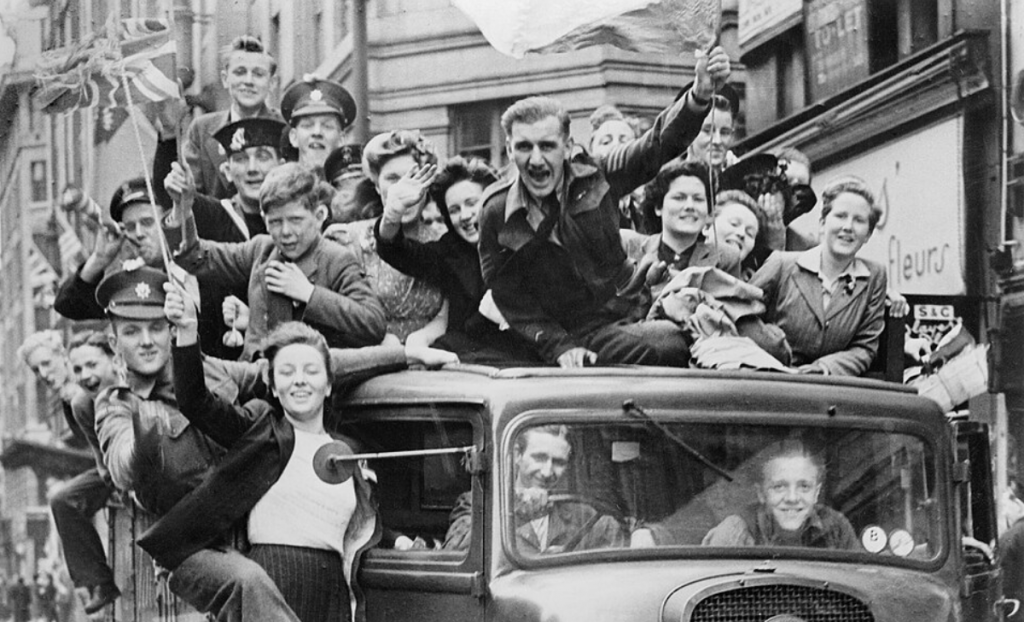 Oslavy Dňa v&iacute;ťazstva v Eur&oacute;pe v Lond&yacute;ne 8. m&aacute;ja 1945. Skupina ľud&iacute; oslavuje koniec druhej svetovej vojny na n&aacute;kladnom aute prech&aacute;dzaj&uacute;com cez Strand. FOTO: Imperial War Museums/HU 41808