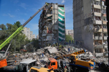 Z&aacute;chran&aacute;ri prehľad&aacute;vaj&uacute; ruiny budovy, ktor&uacute; zasiahol &uacute;tok ruskej arm&aacute;dy v ukrajinskej metropole Kyjev. FOTO: TASR/AP