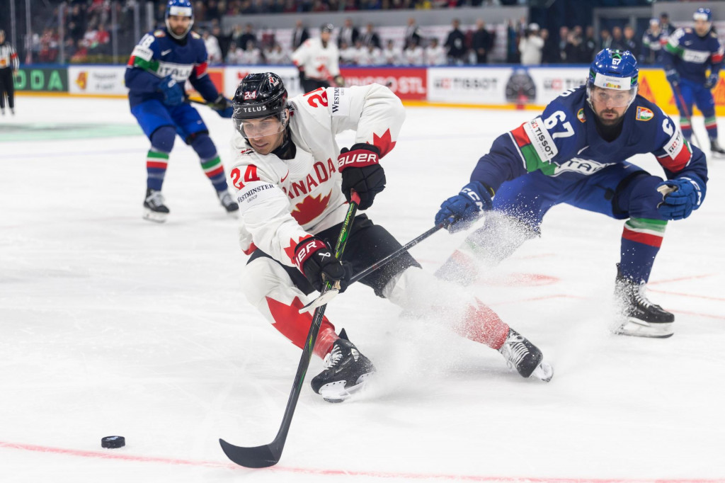 Hr&aacute;č Kanady Dylan Cozens (vľavo) a Mats Frycklund z Talianska v s&uacute;boji o puk počas z&aacute;pasu z&aacute;kladnej B-skupiny Taliansko - Kanada na 89. majstrovstv&aacute;ch sveta v ľadovom hokeji vo &scaron;vajčiarskom Fribourgu v sobotu 16. m&aacute;ja 2026. FOTO TASR/AP