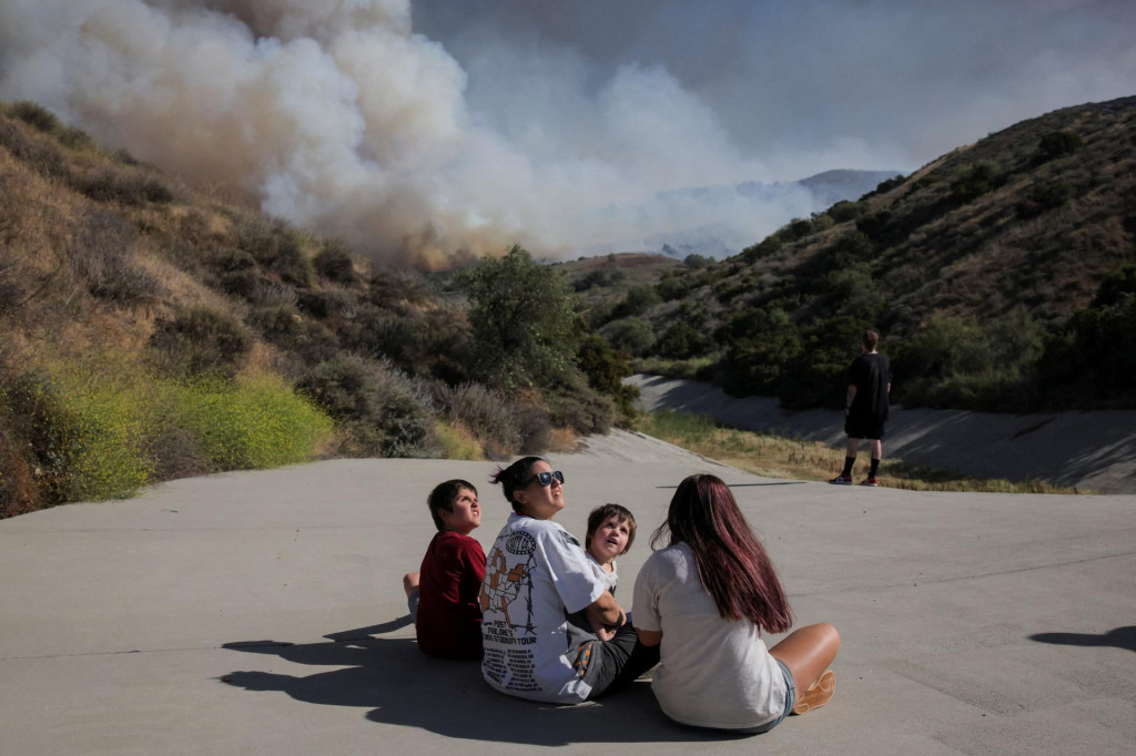 Rodina sleduje hasičsk&eacute; vrtuľn&iacute;ky, ako bojuj&uacute; s lesn&yacute;m požiarom v Simi Valley v Kalifornii. FOTO: Reuters