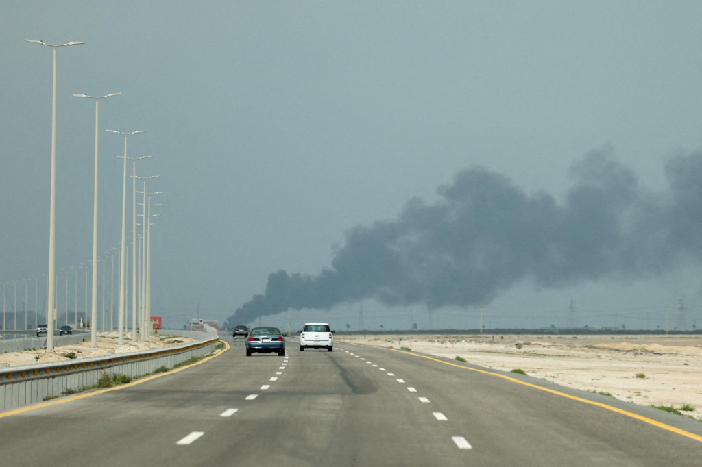 Vozidl&aacute; sa pohybuj&uacute; po ceste, zatiaľ čo sa z ropnej rafin&eacute;rie Ras Tanura spoločnosti Saudi Aramco valia dym po dronovom &uacute;toku v marci 2026. FOTO: REUTERS