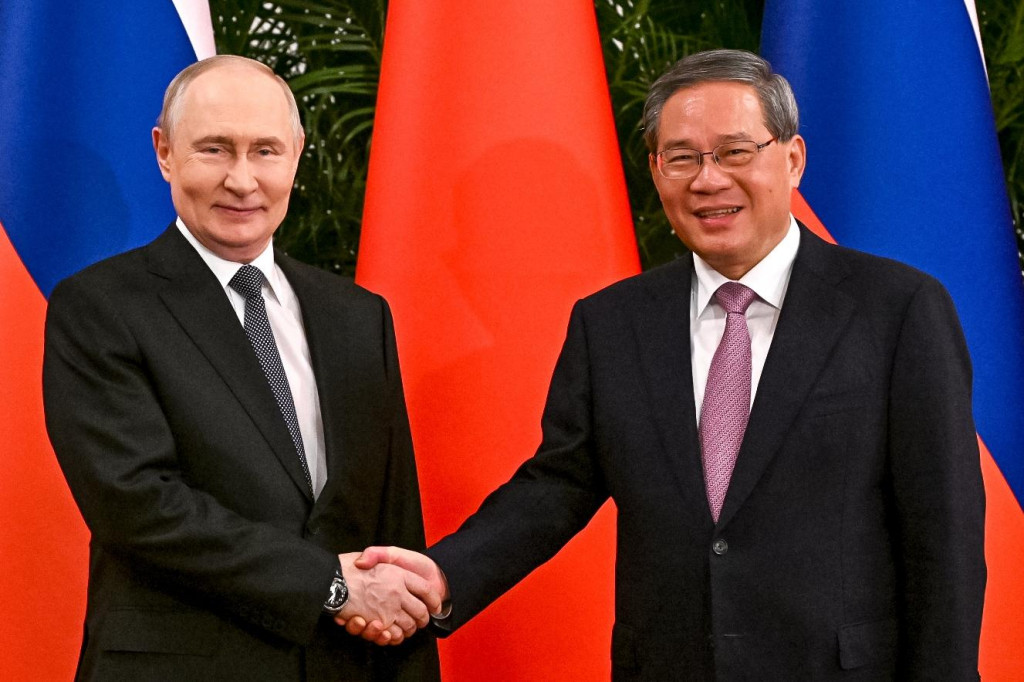 Rusk&yacute; prezident Vladimir Putin a č&iacute;nsky premi&eacute;r Li Čchiang si pod&aacute;vaj&uacute; ruky počas spoločn&eacute;ho stretnutia vo Veľkej s&aacute;le ľudu v Pekingu v stredu 20. m&aacute;ja 2026. FOTO: TASR/AP