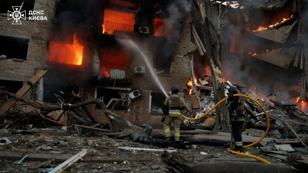 Horiaca budova počas rusk&eacute;ho raketov&eacute;ho a bezpilotn&eacute;ho &uacute;toku v Kyjeve. FOTO: Reuters