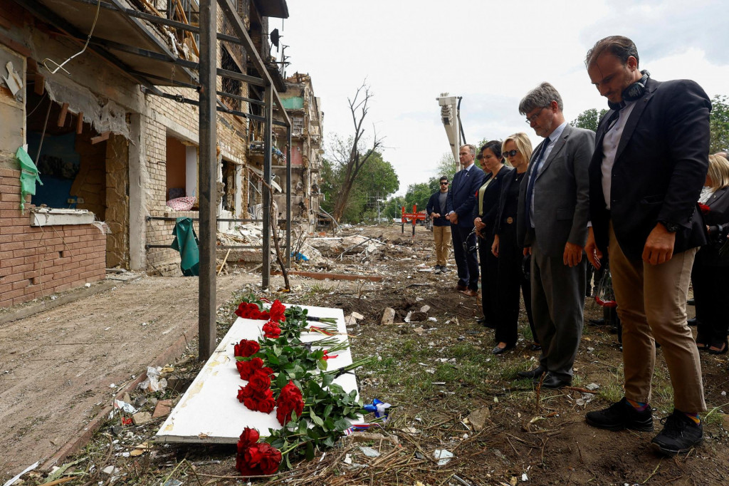 Členovia diplomatick&yacute;ch misi&iacute; na Ukrajine klad&uacute; kvety na miesto zasiahnutia bytov&eacute;ho domu počas ned&aacute;vnych rusk&yacute;ch &uacute;tokov v Kyjeve. FOTO: Reuters