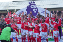 Futbalisti Arsenalu oslavuj&uacute; s trofejou po tom, ako z&iacute;skali titul Premier League. FOTO: TASR/AP