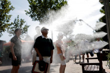 Div&aacute;ci sa počas vlny hor&uacute;čav v Par&iacute;ži ochladzuj&uacute; pri rozpra&scaron;ovači vody. FOTO: Reuters
