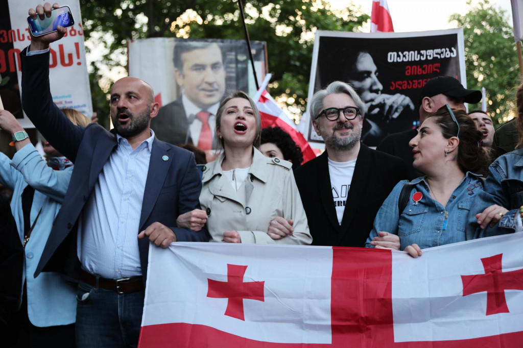 Demon&scaron;tranti držia plag&aacute;ty s fotografiami v&auml;znen&eacute;ho b&yacute;val&eacute;ho gruz&iacute;nskeho prezidenta Michaila Saaka&scaron;viliho počas protestu v r&aacute;mci Dňa nez&aacute;vislosti v meste Tbilisi v utorok 26. m&aacute;ja 2026. FOTO: TASR/AP