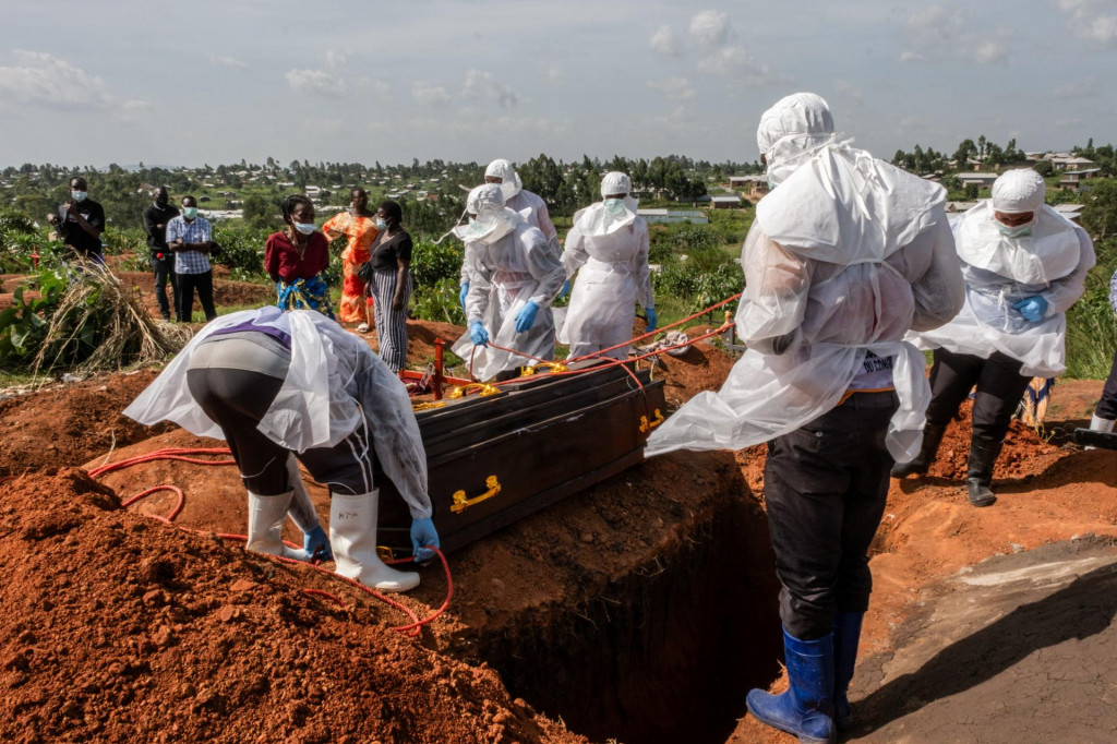 Pracovn&iacute;ci Červen&eacute;ho kr&iacute;ža v osobn&yacute;ch ochrann&yacute;ch prostriedkoch sa pripravuj&uacute; na pren&aacute;&scaron;anie rakvy s telom osoby, ktor&aacute; zomrela na v&iacute;rus Ebola. FOTO: Reuters