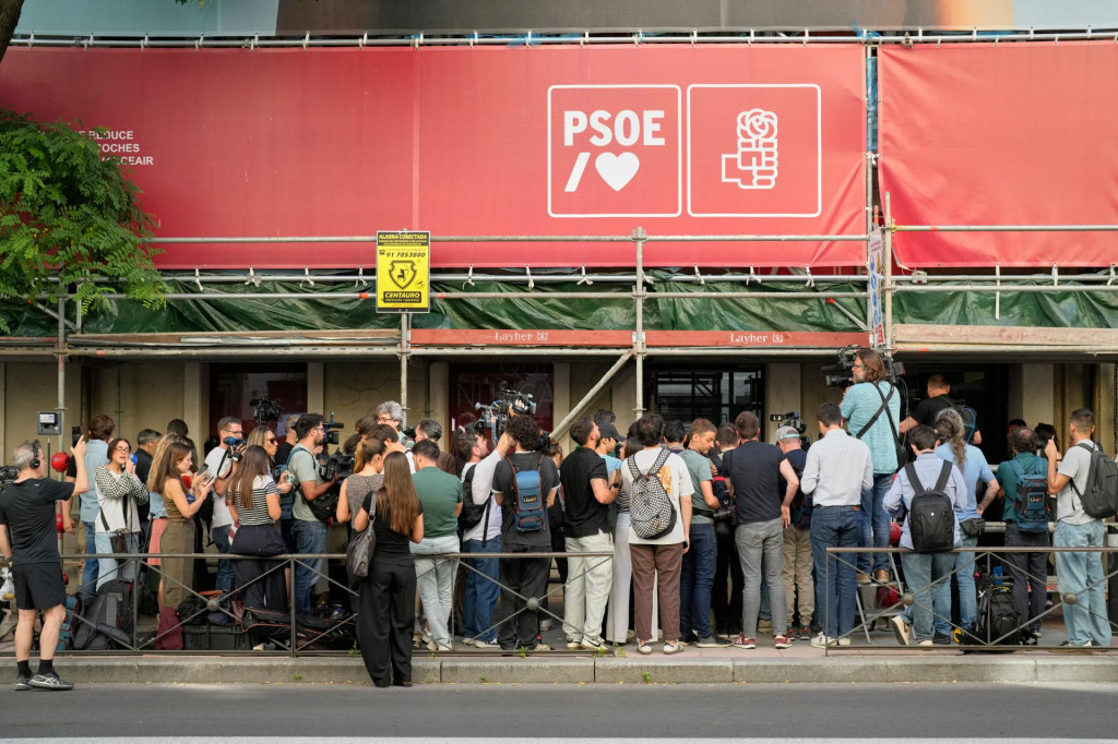Novin&aacute;ri sa zhromažďuj&uacute; pred s&iacute;dlom vl&aacute;dnucej &Scaron;panielskej socialistickej strany počas toho, ako pol&iacute;cia prehľad&aacute;va budovu v Madride. FOTO: TASR/AP