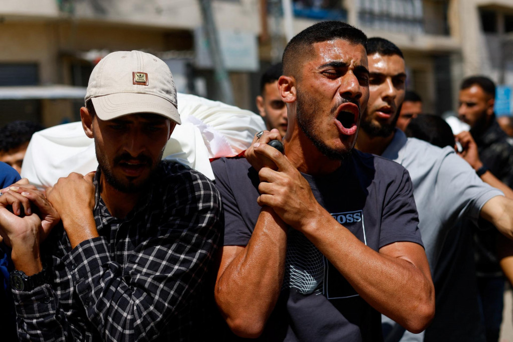 Ľudia nes&uacute; telo, ktor&eacute; sm&uacute;tiaci identifikovali ako veliteľa vojensk&eacute;ho kr&iacute;dla Hamasu Muhammada Al&iacute;ho Awdu. FOTO: Reuters