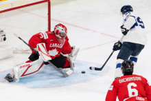 Brank&aacute;r Kanady Jet Greaves, ktor&eacute;ho prekon&aacute;va hr&aacute;č F&iacute;nska Konsta Helenius. FOTO: TASR/AP