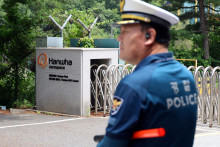 Policajt kontroluje oblasť pred hlavnou br&aacute;nou tov&aacute;rne spoločnosti Hanwha Aerospace, ktor&aacute; zachv&aacute;tila požiar po v&yacute;buchu. FOTO: Reuters/Jonhap