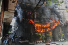 Ľudia sa snažia uhasiť požiar hotela v Nai Dill&iacute;. FOTO: TASR/AP