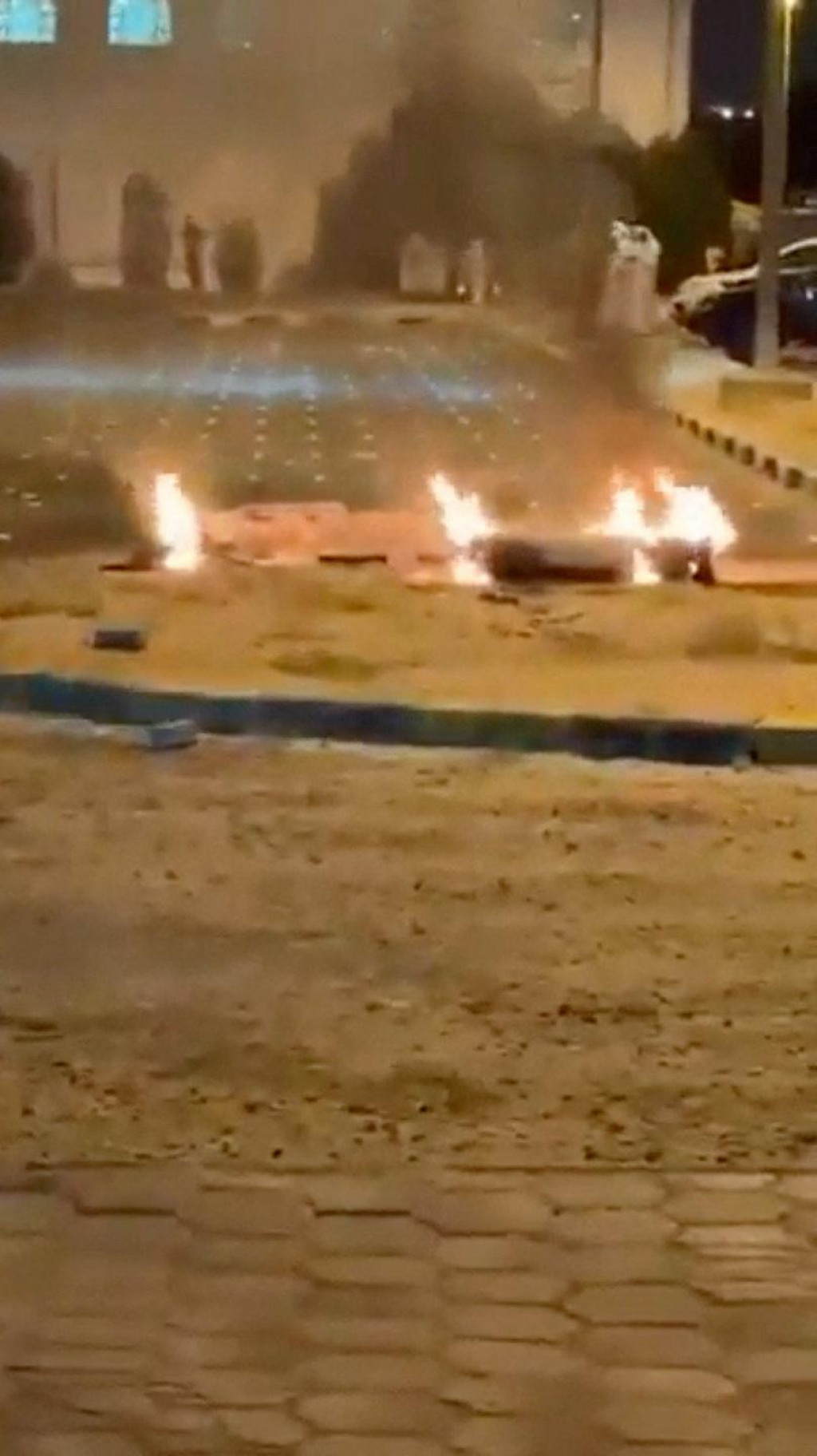 Trosky horia na zemi na parkovisku v Sabah Al Nasser v Kuvajte. FOTO: Reuters