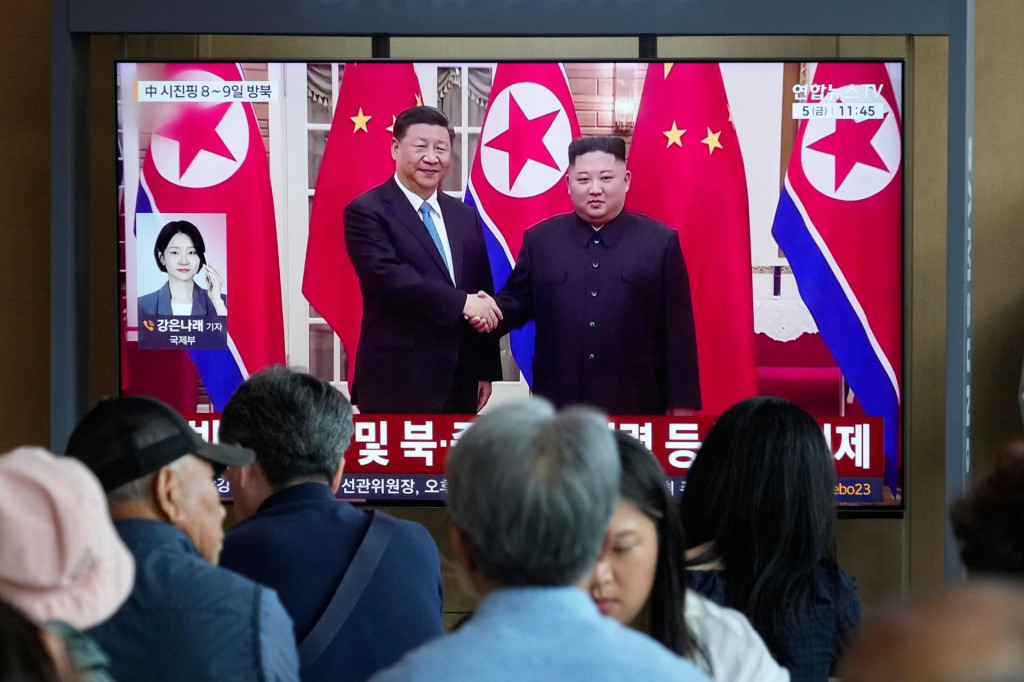 Na telev&iacute;znej obrazovke fotografia severok&oacute;rejsk&eacute;ho vodcu Kim Čong-una a č&iacute;nskeho prezidenta Si Ťin-pchinga na železničnej stanici v Soule. FOTO: TASR/AP