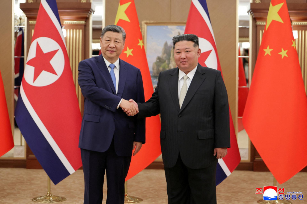 Č&iacute;nsky prezident Si Ťin-pching si pod&aacute;va ruku so severok&oacute;rejsk&yacute;m vodcom Kim Čong-unom. FOTO: Reuters/KCNA