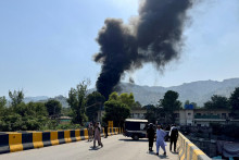 Ľudia a pol&iacute;cia sa zhromažďuj&uacute; neďaleko, zatiaľ čo sa dym val&iacute; z miesta, kde sa zr&uacute;til vrtuľn&iacute;k Mi-17 pakistansk&eacute;ho arm&aacute;dneho letectva. FOTO: Reuters