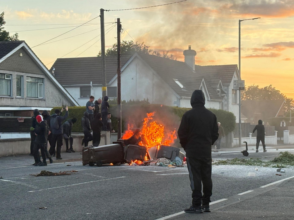 V Belfaste tis&iacute;ce nahnevan&yacute;ch a zamaskovan&yacute;ch &Iacute;rov sa vrhli do mestskej časti, kde žij&uacute; prevažne imigranti. FOTO: Reuters/Isabel Infantes