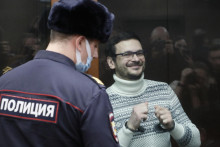 Rusk&yacute; opozičn&yacute; l&iacute;der, b&yacute;val&yacute; moskovsk&yacute; mestsk&yacute; poslanec Iľja Ja&scaron;in, stoj&iacute; v sklenenej klietke pre obžalovan&yacute;ch pred vynesen&iacute;m rozsudku na Me&scaron;čanskom okresnom s&uacute;de v Moskve (9. decembra 2022). FOTO: Reuters